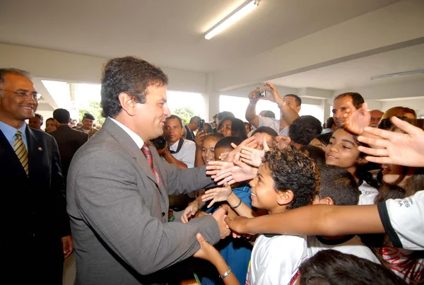 Aécio Neves cumprimenta crianças na chegada à solenidade de inauguração do 41º Batalhão da PM