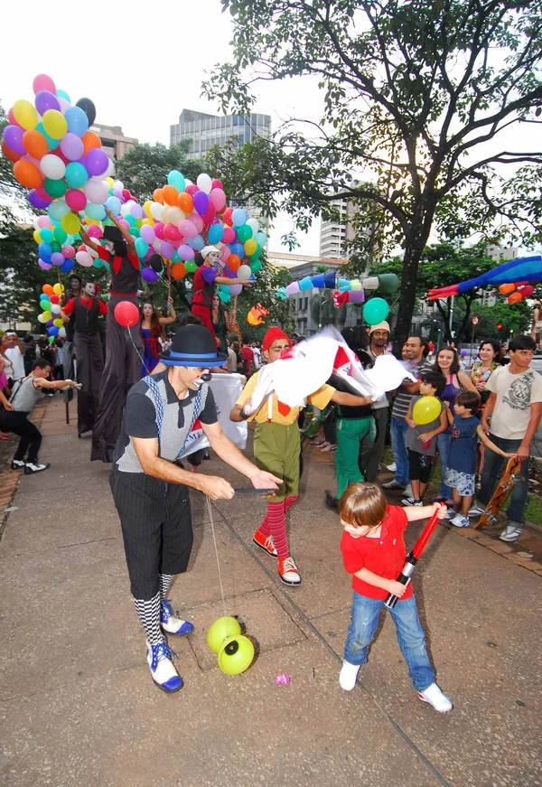 Criança se diverte com a apresentação de palhaços na Praça da Liberdade