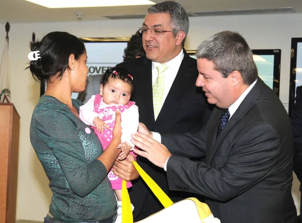 Antonio Anastasia brinca com criança no lançamento do Projeto Mães de Minas