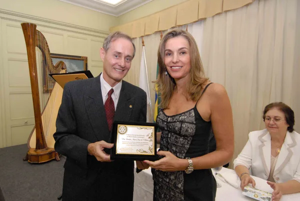 Renata Vilhena recebe do presidente do Rotary Club de BH, Sérgio Americano Mendes, placa comemorativa dedicada ao mês da mulher