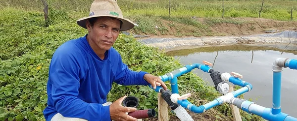 Produtor Zé Brasil ao lado do tanque usado na irrigação de salvamento